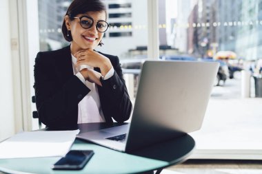 Neşeli işkadını Cafe müreffeh kariyeriyle tatmin uzak iş dizüstü bilgisayarda yazılım güncelleme portresi. Başarılı bir tüccar laptop oturan kamera gülümseyen şık resmi aşınmaya