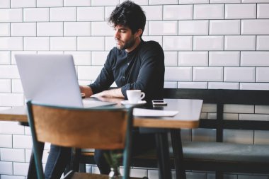 Zeki öğrenci modern dizüstü bilgisayar sınavları için hazırlık şık siyah gömlek giymiş bağlı kablosuz 4 g için internet kafede oturuyor. Yaratıcı grafik tasarımcı netbook çalışma