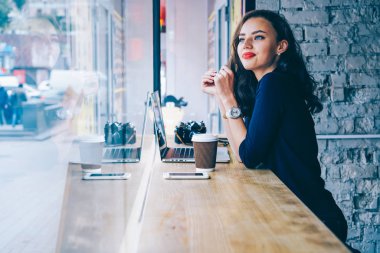 Güzel bir rüya gibi genç kadın moda giyim kahvehane iç modern dijital dizüstü bilgisayar ve aroma içecek ile oturup kendi web sitesi oluşturmak için ilginç fikirler üzerinde durulması