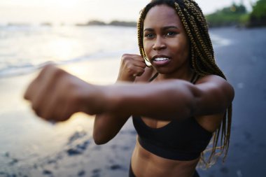 Koyu tenli motive sportif kız tropik ada deniz kıyısında sabah egzersiz sırasında boks egzersizleri yapın. Plaj günü etkin üst eğitim profesyonel sportwoman konsantre