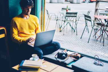 Kurs yazarak ve modern dizüstü bilgisayar aygıt Web sitelerinde bilgi aramada sakallı öğrenci bağlı 4 g için Internet. Sohbet online sosyal ağlar bilgisayarda coworking içinde oturan genç adam