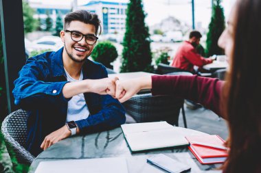 Kız arkadaşım kafe Teras, neşeli genç adam başarılı proje ortağı eklemleri ile Tamamlanıyor zevk toplantısı ile karşılama oturum açma gözlük darbeleme neşeli hippi herif yumruklar