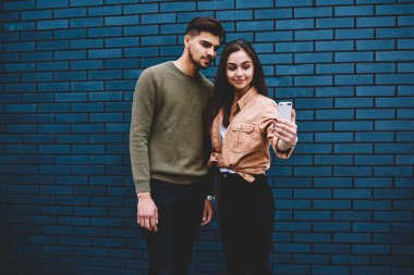 Selfie sosyal ağlar görüntü paylaşımı için poz genç erkek ve dişi hipsters modern smartphone kamera ayakta promosyon arka plan, kaç içinde fotoğraf yapma rahat şık kıyafeti seviyorum