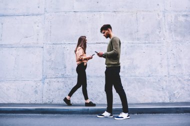 Erkek ve dişi hipsters birbirimizi görmezden gri duvar arka plan üzerinde yürüme tercih sosyal ağlar, sohbet online pon tanıtım alanı geziniyor gerçek hayatta iletişim yerine öğrenciler