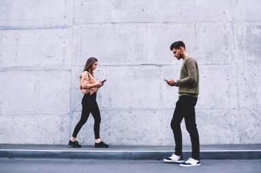 Tanıtım alanı yakınında sokakta yürürken gençlerin teknoloji online, vakit erkek ve dişi hipsters sosyal ağlar ve dijital cihazlar için bağımlısı akıllı gezinme yoğunlaşmıştır.