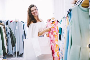 Mutlu çekici tasarımcı uygun portresi seçme giyim moda butik alışveriş ücretsiz vakit bak. Neşeli erkek moda kıyafet alışveriş mağazası içinde oluşturmak için giysiler seçmek
