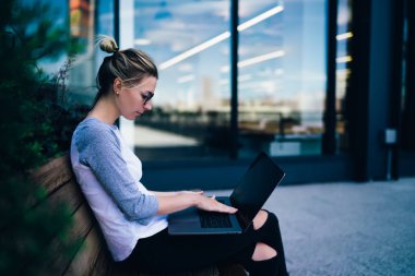 Açık havada downtow boş zamanlarımda sırasında ağlar haber okuma dizüstü bilgisayar web sayfasında tarama hippi kız bankta, otururken öğretici arama netbook klavye dalgın kız öğrenci