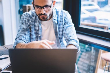 Konsantre erkek bu geliştirici netbook üzerinde uygulama yükleme ve onarma yazılım, çevrimiçi web sayfasında üzerinde işlem ödeme yapma bilgi okuma hipster adam uzak iş yapıyor