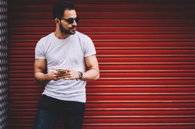 Yakışıklı adam rahat giyim smartphone Ağ kentsel promosyon arka plan yakınında sokakta vakit genç hipster adam açık havada için telefon kullanarak bloglama dinlenme upload fotoğraf