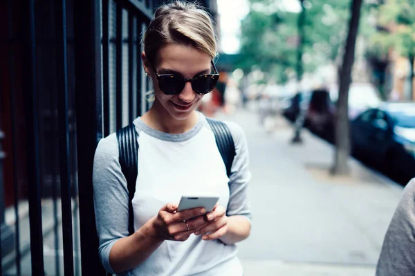 休暇中に観光 流行に敏感な女の子サングラス メール チェックと携帯電話のストレスマネジメントの散歩に関するフィードバックを送信しながらサイトの町に関する情報を読む若い女性旅行者 — ストック写真