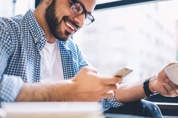 Erkek arkadaşımdan VI hücresel kafede eğlence sırasında sohbet kısa mesaj alma ile memnun gülümseyen mutlu hipster adam smartphone ağ online yarışma zafer ile heyecanlı