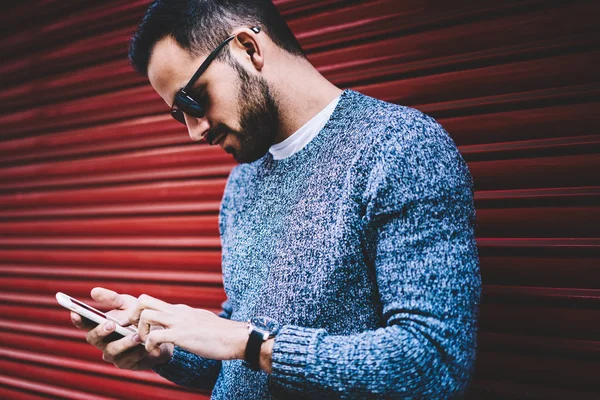 Yakışıklı adam açık havada, hipster adam bloglama sosyal ağlar üzerinde kentsel ayarları hücresel harcama boş dosya yükleme ayakta şehirde café arama için smartphone uygulama kullanarak