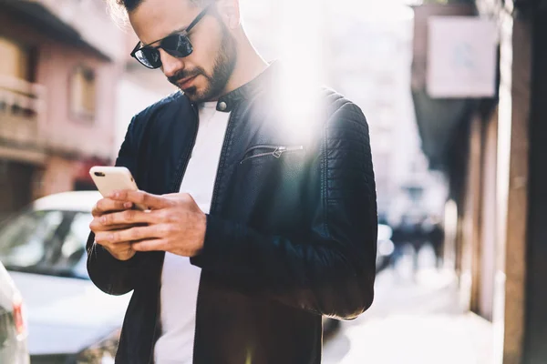 年轻男性检查通知和阅读新闻智能手机漫步在城市街道上 英俊的时髦的家伙使用银行在现代蜂窝网上的应用 方便在线支付 — 图库照片