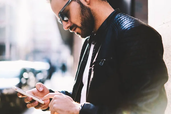 在手机上使用蜂窝上的聚焦男性图像在网上银行站在街上 时髦的家伙阅读智能手机发送多媒体信息的通知户外 — 图库照片