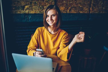 Başarılı kadın tasarımcı gönderme sms mesajı café'de bilgisayar bitirme uzak iş hakkında yarım uzunluk portre. Pozitif hippi kız coworking içinde laptop öğrenim smartphone cep telefonu ile app yükleme