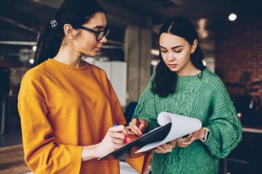 Kadın öğretmen Üniversitesi'nde dururken beyin fırtınası sırasında yetenekli öğrencinin eğitim proje kontrol gözlük tasarımcısında. Çalışma planı tartışmaya iki profesyonel arhitects