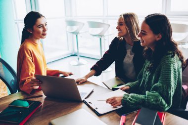 Başarılı iş kadınları birbirleri ile yeni fikirler ve tablo bilgisayar ile toplantı oturan sabah brifing sırasında kendi başlangıç projesi geliştirmek için verimli stratejiler hakkında iletişim