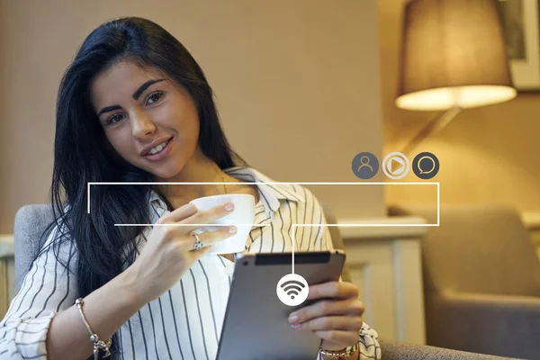 Portrait of attractive young woman resting in cafe with cup of tea and digital device connected to wifi for blogging, beautiful young woman enjoying coffee using tablet applications. Infographics sign