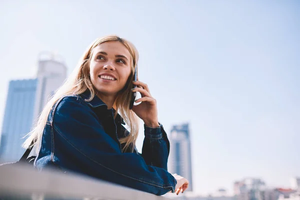 Sonriente Joven Rubia Hablando Smartphone Itinerancia Pie Sobre Fondo Metropolitano —  Fotos de Stock