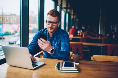 Kurs, dizüstü bilgisayar üzerinde çalışan kablosuz 4 g için bağlıyken smartphone aygıt üzerinde gelen bildirim okuma Kızıl saçlı yetenekli öğrenci alan coworking oturan internet