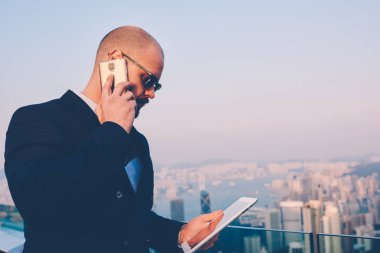Finansal raporlar ve smartphone ayakta balcoy teras manzaralı metropolis bazı detay hakkında konuşurken için istek-e doğru çalışan sungasses alınan e-posta içinde icra müdürü yan görünüm
