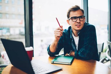 Genç yakışıklı pozitif yetenekli BT geliştirici giyinmiş şık kapalı iş elbiseleri uzaktan sırasında biraz ara verdim. Makale yayın için iyi fikirler düşünmeye yaratıcı erkek blogger gülümseyen