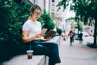 Gün arama bilgi ağları tarama web sayfasında telefon, Çinli genç kadın arama numarasına şehir merkezinde iş molası sırasında dinlenme Not Defteri'nden planlama gözlük dalgın Asyalı kız