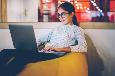 Dizüstü bilgisayar, netbook metin yayın web sayfası için online para yazarak kazanç zevk pozitif kadın serbest meslek film izlerken uzay coworking istirahat olumlu esmer hippi kız