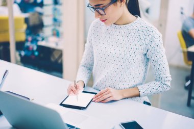 Konsantre kadın yönetici Online imza dijital tablet ve ofis organizasyon iş kalem ile yaratıcı kadın touchpad netbook için bağlı tasarımcı çizim kroki üzerinde makaleler