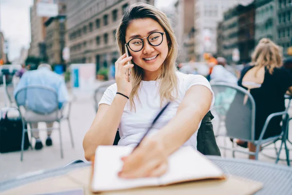 Felice Giovane Donna Asiatica Notando Nel Diario Mentre Parla Con — Foto Stock