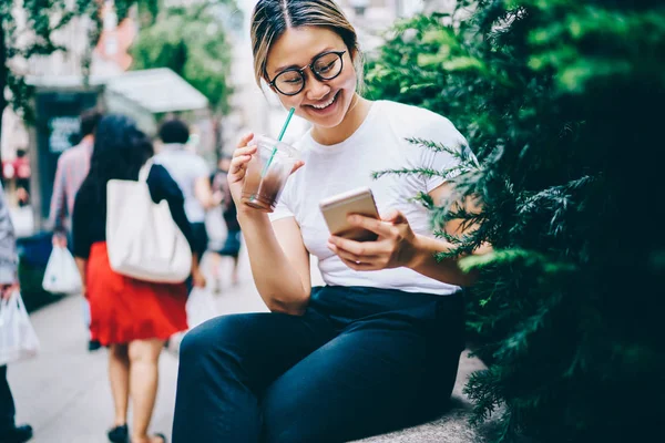 Wesoły Asian Kobieta Okulary Picia Kawy Lód Zewnątrz Czytanie Dochód — Zdjęcie stockowe