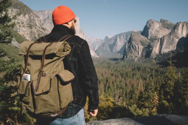 Yolculuk tutkusu adventur sırasında hipster adam adimire doğal doğa, Yosemite Milli Parkı doğa manzara nefes kesici manzarayı turistik turistik sırt çantası ile arkadan görünüşü erkek uzun yürüyüşe çıkan kimse