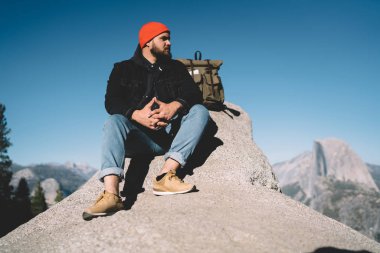 ABD, zevk yolculuk tutkusu Milli Parkı turistik sırt çantası journe sırasında oturan adam hafta sonları vahşi çevre keşfetmek Tur hiking sırasında kaya tepe üzerinde dinlenme dalgın hipster adam