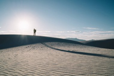 Erkek kişi yolculuk tutkusu ayakta seyahat yaşam tarzı Durin'in günbatımı güzel kumulları en yüksek zevk özgürlüğü silüeti. Adam yolculuk tutkusu ayakta kum tepe üzerinde gündoğumu sahne doğa manzara içinde