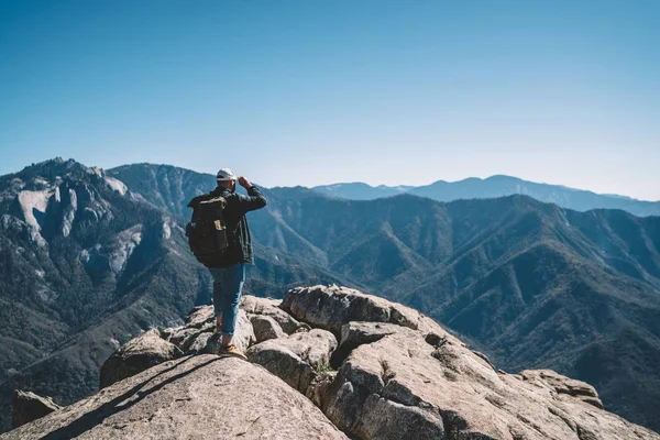 从高石山流浪享受惊险的风景的时髦家伙的后面看法 男性旅行者与背包再造探索野生自然看山山顶风景在夏天 Vacatio — 图库照片