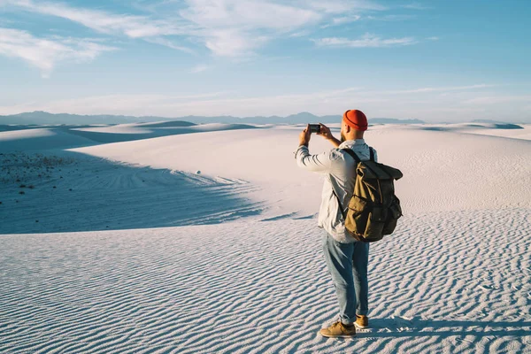 Visão Traseira Explorador Masculino Com Mochila Fazendo Foto Dunas Deserto — Fotografia de Stock