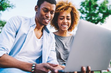 Birlikte laptop kamera için poz komik surat Afro Amerikan hipsters zevk zaman, tarih boyunca netbook ve 4 g bağlantısı kullanarak arkadaşına şaka yapma video aşk mutlu çift ara