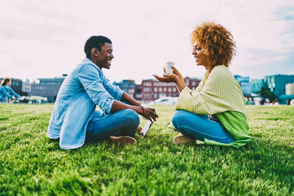 快乐的美国黑人最好的朋友一起在城市公园的绿色草坪上重新创建 幸福的情侣在交谈中享受在阳光明媚的春天的户外约会时的爱笑 — 图库照片