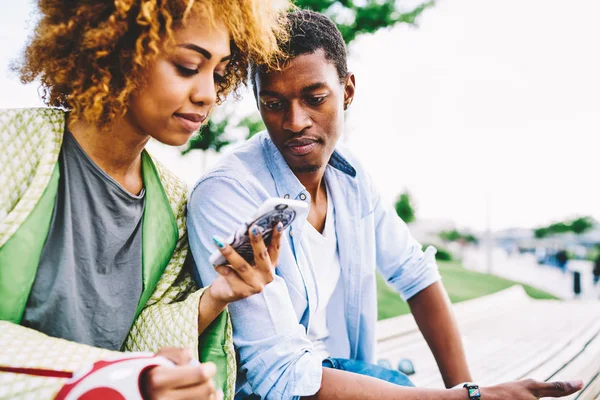 情侣相爱搜索位置在网上地图上的手机 而在一起花时间 美国黑人最好的朋友看视频在线上的智能手机享受交流在日期 — 图库照片