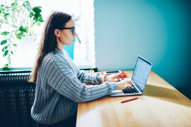 Yayın tasarım Web sitesi için oluşturma dizüstü bilgisayarda yazarak Eyewear kadın serbest meslek yan görünüm. Geribildirim netbook üzerinde sosyal ağ sohbet arkadaş için klavye metin yazarı konsantre