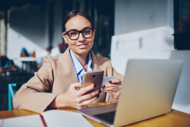 Güzel genç kadın gözlük ve kartvizit el kameraya gülümseyen süre iş teklifleri web sitelerinde arama yarım uzunluk portre. Çekici Bayan smartphone telefon numarasını çevirme