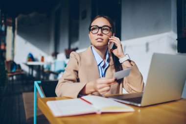 Düşünceli güzel kadın yeni tarife planı Smartphone cep telefonu ile bağlanma hakkında danışmanlık için operatör arıyorum. Genç kadında akıllı cep telefonu üzerinden iş işveren ile söz gözlük