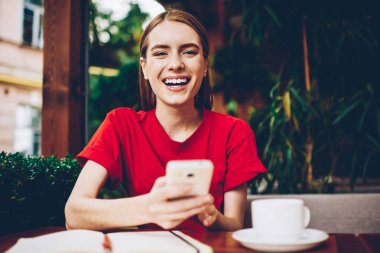 Yarım uzunluk portre fotoğraf makinesi vasıl yüksek hız 4 g internet bağlantısı ile smartphone için yeni app yüklerken gülüyor neşeli şirin Blogger. Pozitif kadın cep üzerinde komik bildirimi alındı