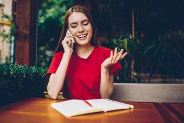 Kafe açık havada uzak iş sırasında smartphone üzerinde konuşmaya başlamak-yukarıya için fikirler tartışıyor güzel yaratıcı genç kadın. Kadın sahibi iş planı meslektaşım telefon görüşmesi sırasında açıklayan.