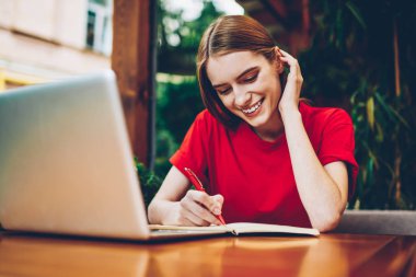 Yetenekli öğrenci için dizüstü bilgisayar kullanarak uzaktan yaratıcı başlangıç proje çalışma planı notlar yazma. Başarılı genç kadın, netbook oturup Not Defteri'nde grafik ve skeçler göstermek için kullanılan proje çizim