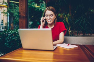 Başarılı kadın genç kadın webstores ücretsiz yüksek hızda internet bağlantısı açık havada kahve dükkanı iç oturan üzerinden dizüstü cihaz üzerinde tarama yaparken Danışmanlık Yöneticisi ile smartphone üzerinde söz