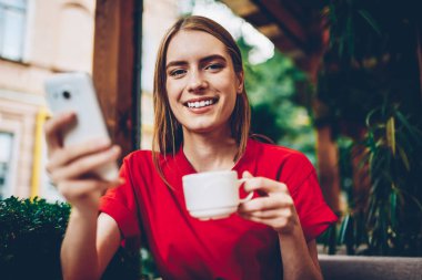 Yarım uzunluk portre pozitif Blogger kendi web sitesi üzerinden yüksek hızlı internet bağlantısı cep telefonunda ise kahve içme ve kameraya gülümseyen Multimedya ve paylaşım yazılarda güncelleştiriliyor