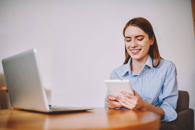 Ücretsiz yüksek hızlı internet bağlantısı'nı kullanarak yeni bir dil öğrenmek için modern dokunmatik yüzey üzerinde uygulama yükleme yetenekli genç kadın. Neşeli öğrenci webstore tablet ile online ödeme yapma