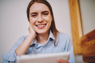 Yarım uzunluk portait e-öğrenme sırasında yüksek kullanarak kameraya gülümseyen güzel öğrenci Iternet dijital tablet üzerinde hız. Güzel ve genç birbayan aygıtta yeni uygulamalar için dokunmatik yüzey üzerinde yazılım güncelleme