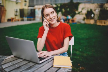 Successfil eğitim projesi ile dizüstü bilgisayar çalışma ve sonraki yaklaşan sınav açık havada kampüs topraklarında oturan için hazırlanıyor süre smartphone aygıt üzerinde konuşmak meşgul gülümseyen öğrenci